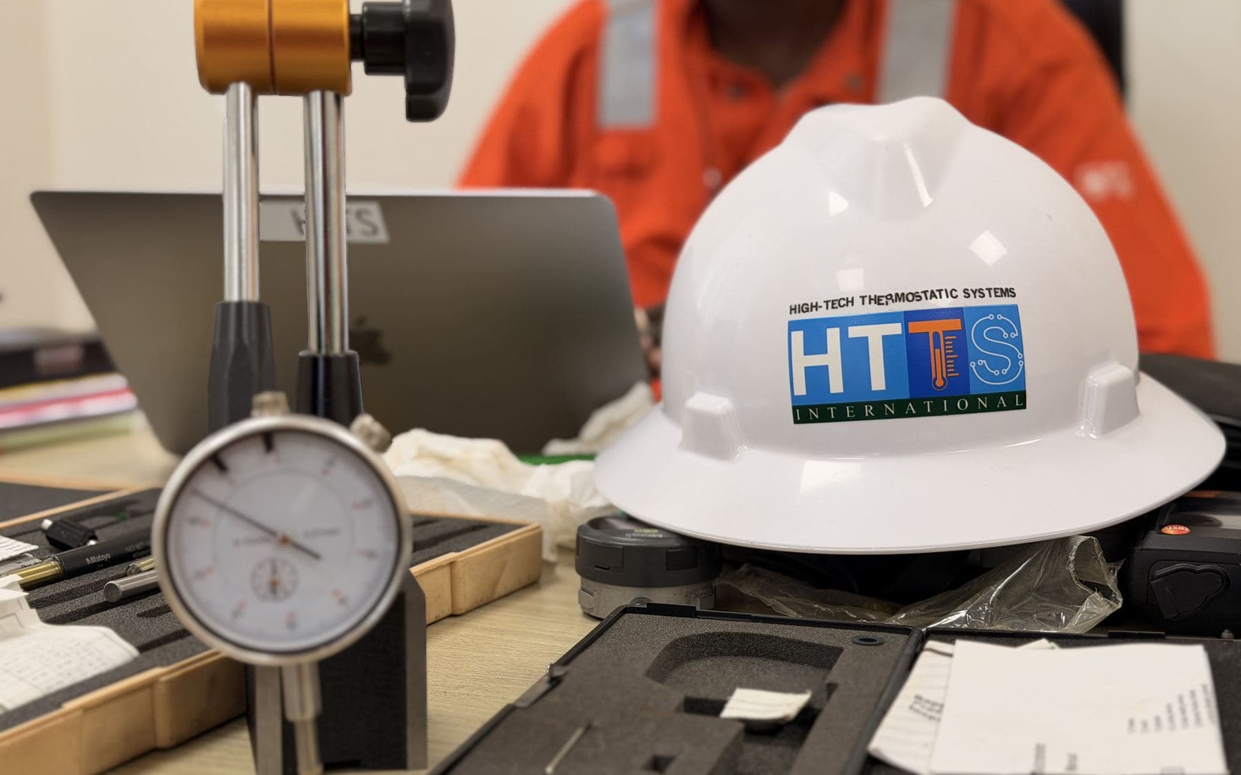 Dial gauge on its stand in front of an HTTS helmet, in the metrology workshop