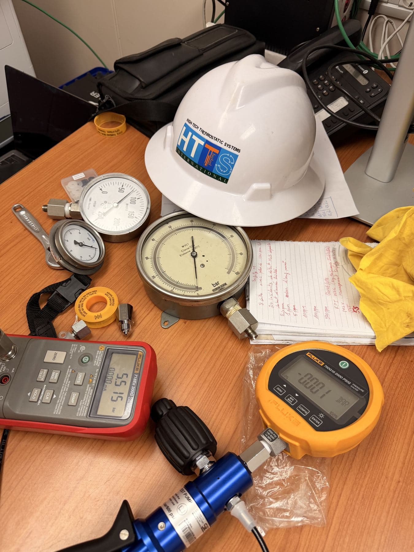 Reference pressure gauges and an HTTS helmet on a verification bench